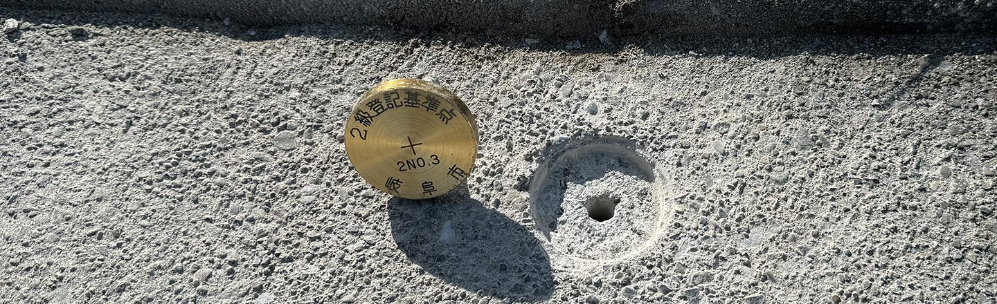 土地の境界標（基準点）と境界確定測量の様子